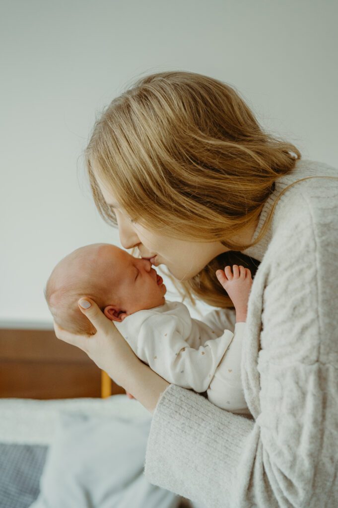 Mama całująca dziecko w nowek.