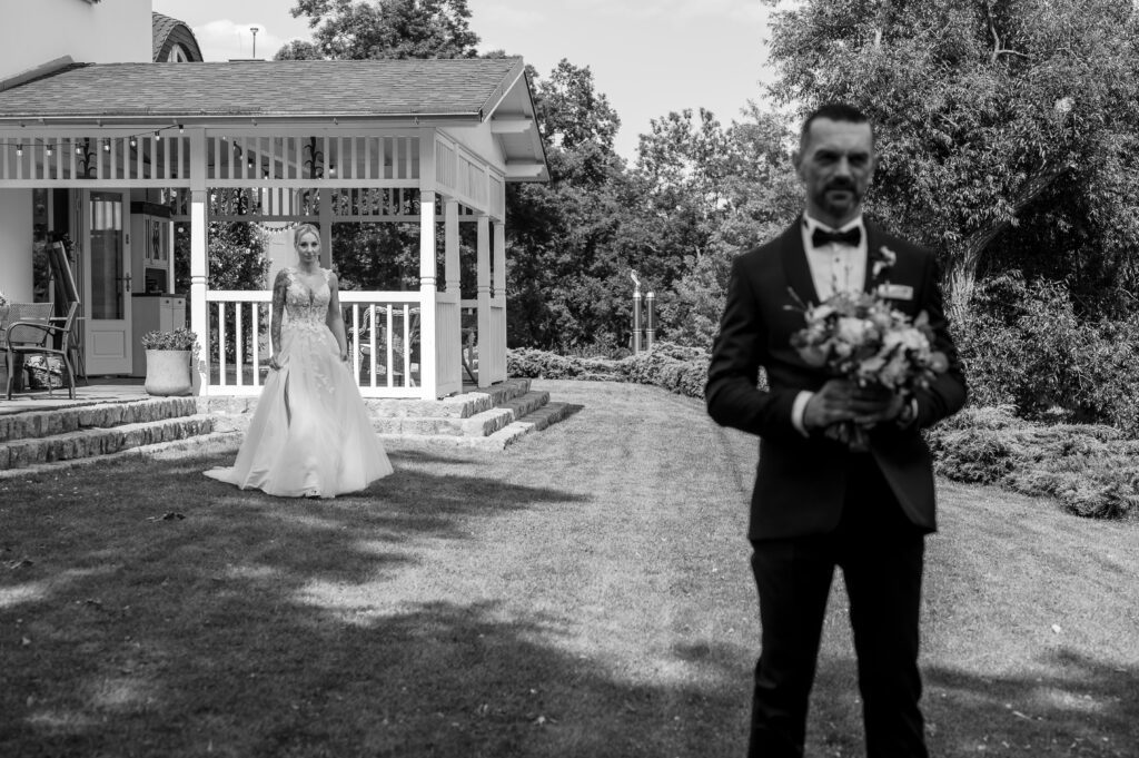 First look. Pan młody czeka na swoją narzeczona w ogrodzie.