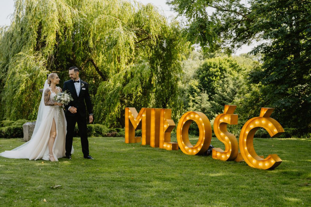 Napis świetlny miłość i para młoda spoglądająca na siebie.