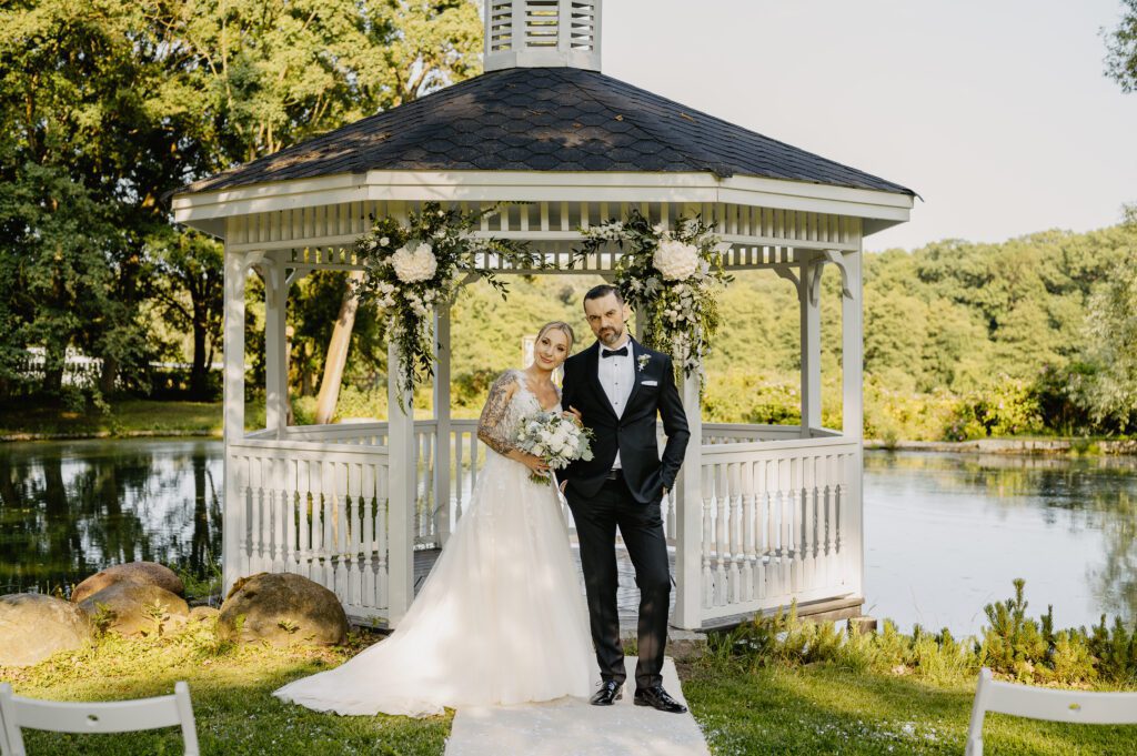 Sesjazdjęciowa w dniu ślubu. Piękna pogoda, altana i jezioro w tle.