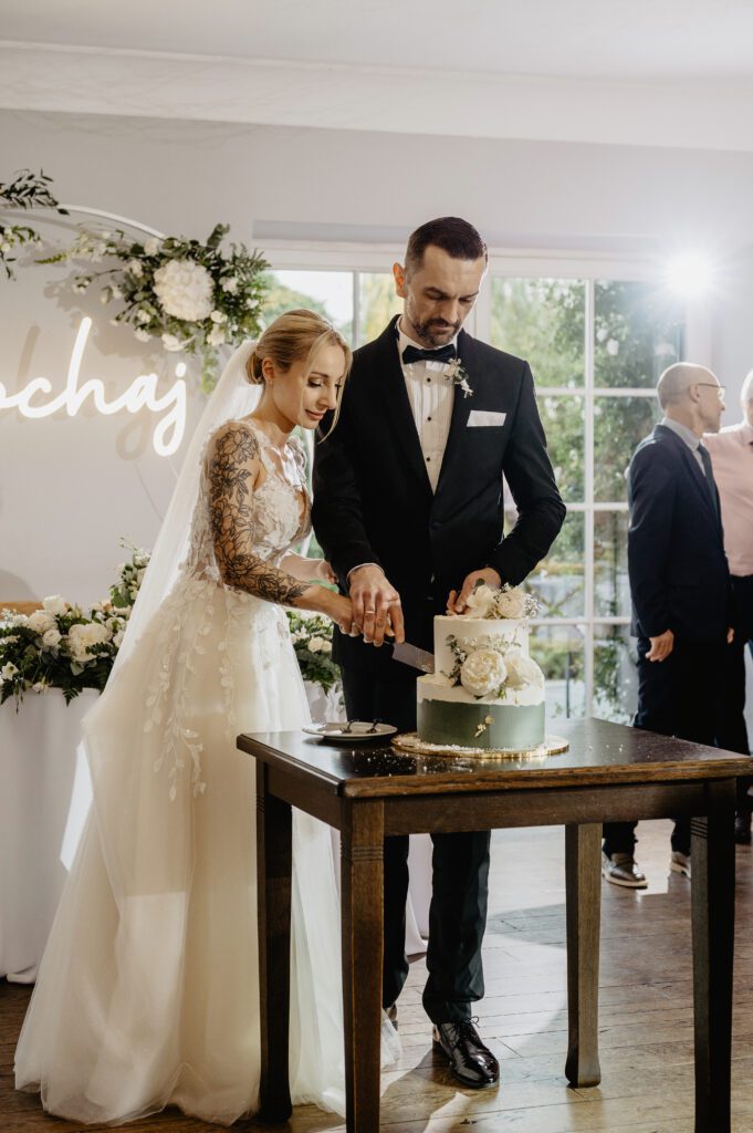 Para młoda kroi tort weselny.