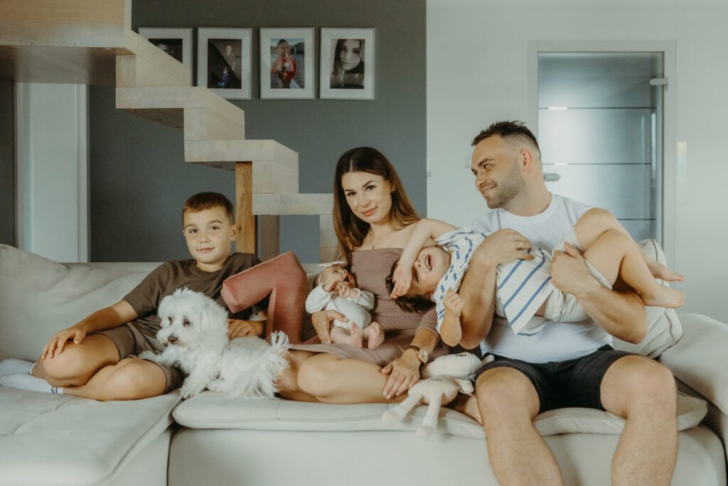 DSC_3551 rodzice z noworodkiem i dwoma synami oraz psem na kanapie