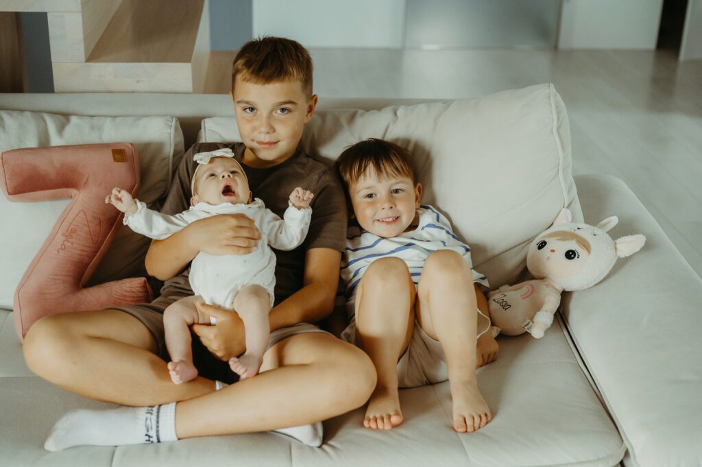 Z6A_3412 najstarszy brat trzyma siostrę na rękach, a młodszy się przytula