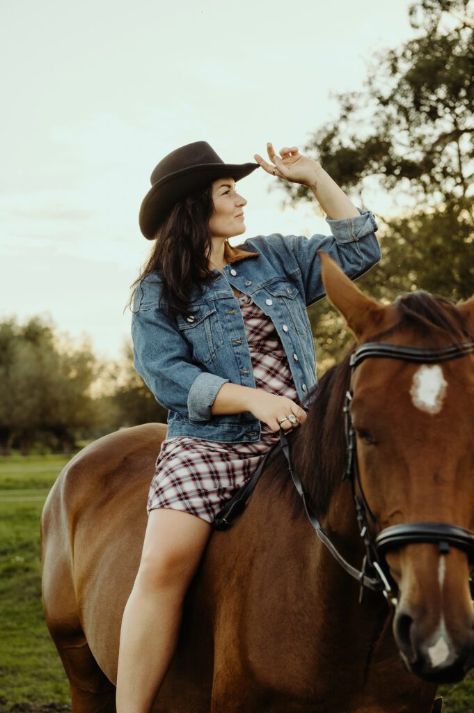 kobieta na koniu w kapeluszu kowbojskim i sukience