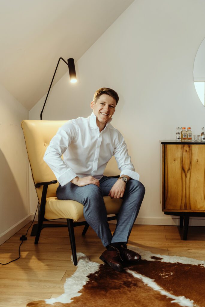 300525_0060 pan młody Michał przygotowania, patrzy prosto w kamerę i uśmiecha się