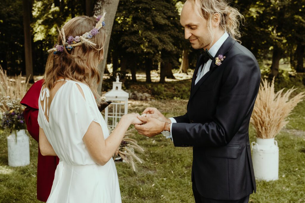 _DS15173 Przysięga ślubna w ogrodzie w Baborówku, moment założe nia obrączek