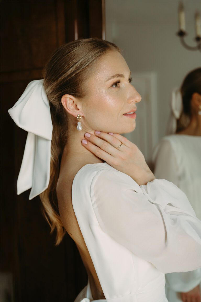 Portret panny młodej. Widać jej profil, kolczyki, pierścionek zaręczynowy.