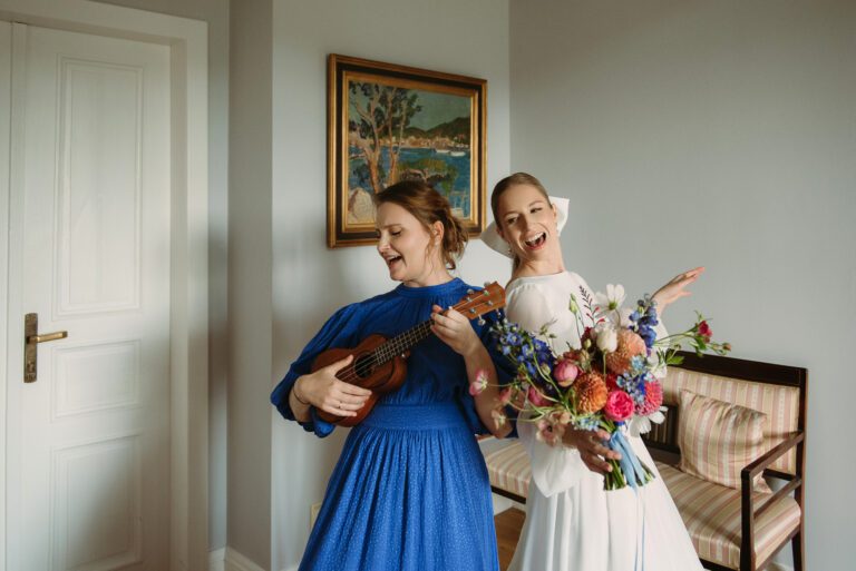 Panna młoda i jej świadkowa. Wsp&oacute;lnie śpiewają ubrane w sukienki.