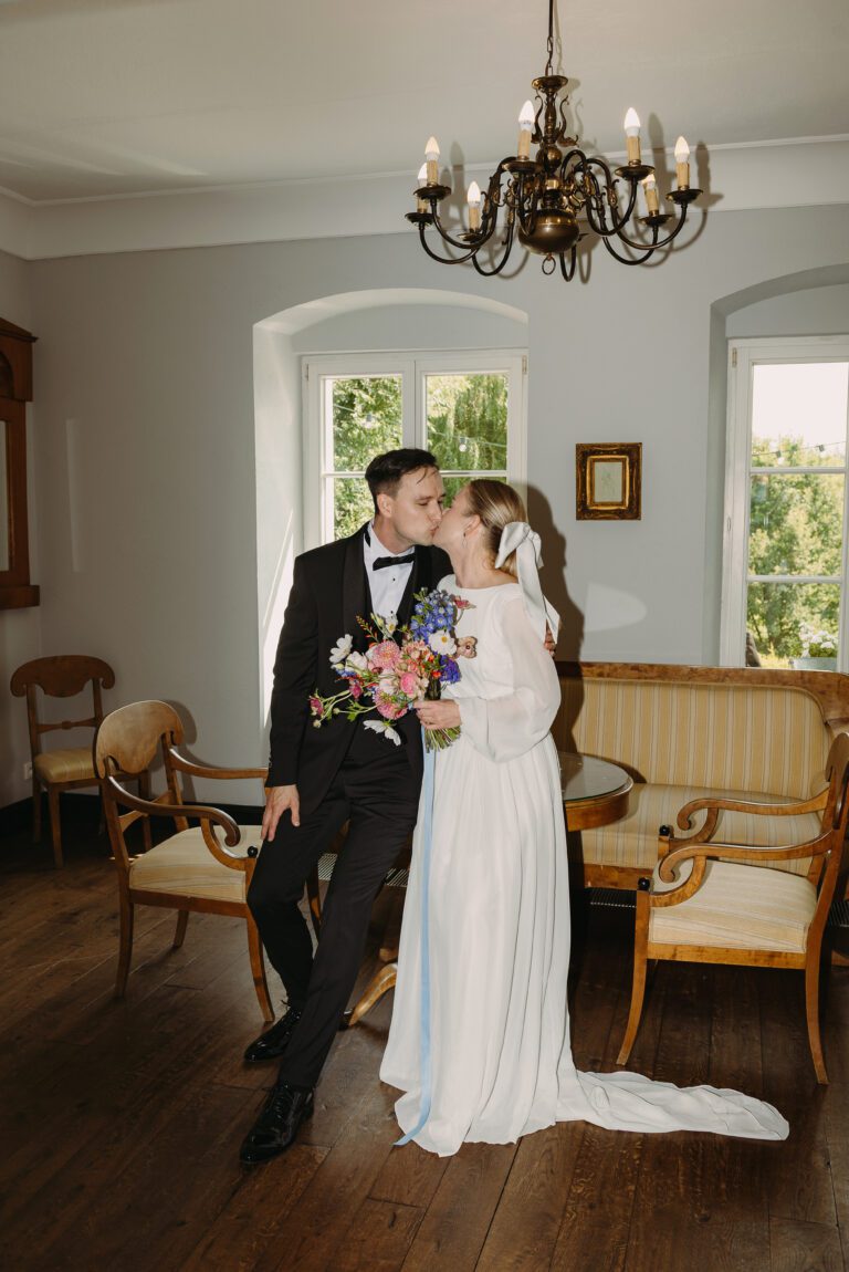 Całująca się para młoda siedząca na stoliku w pokoju w Dworze Wierzenica.