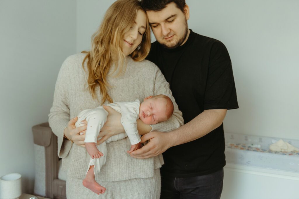 Noworodek w pozycji lemurka. Sesja noworodkowa rodzic&oacute;w z noworodkiem.