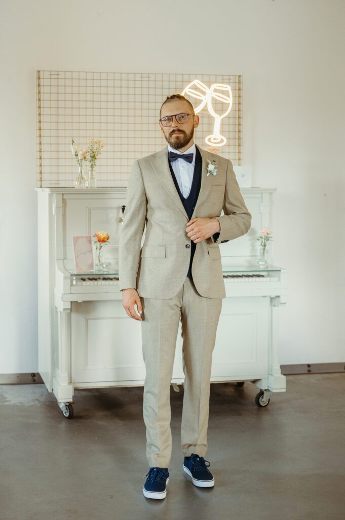 Pan młody na tle stylowego białego pianina.