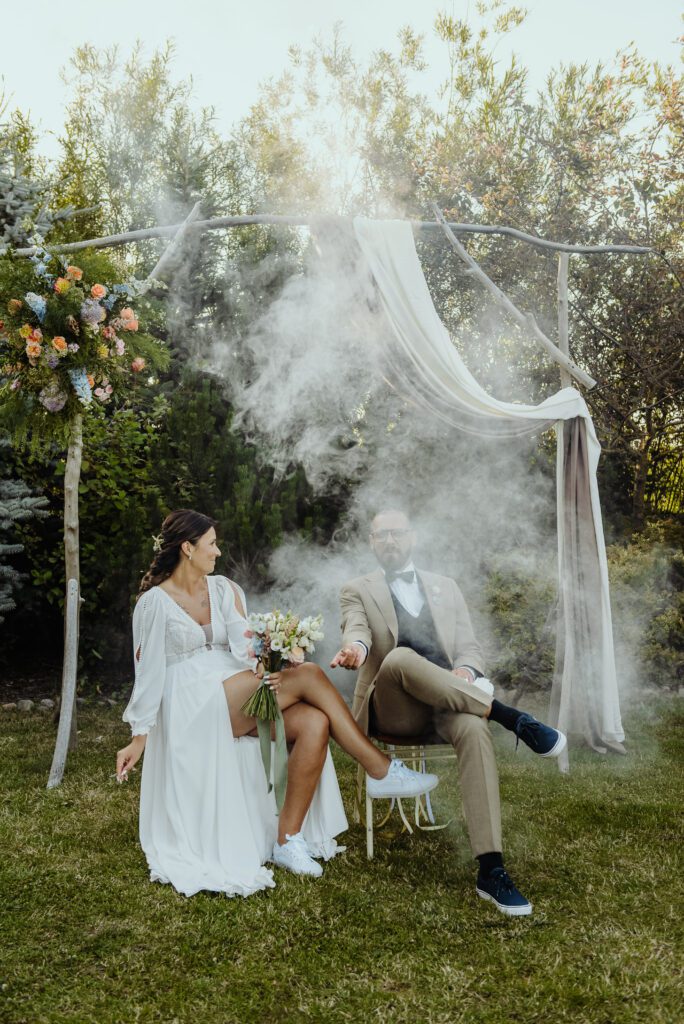 Filmowe ujęcie pary młodej siedzącej na krzesłach i palących papierosy.