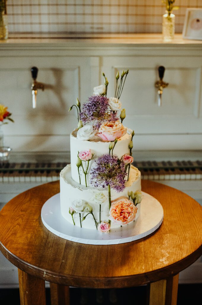 Tort weselny od Patrycji Wesołek Słodkości Wesołke ubekorowany żywymi kwiatami.