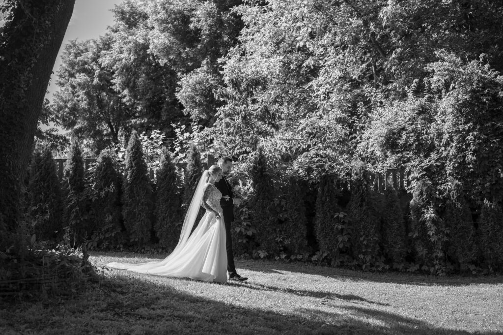 Para młoda idzie do ołtarza w plenerze, w ogrodzie w Dworku Wierzenica.