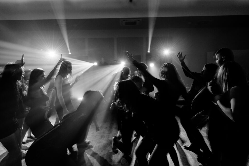 Kinowy, cinematic klimat podczas 18 urodzin. Przygaszone światłą, tylko światłą ze stanowiska dj. Klimat i nastr&oacute;j na fotografii.